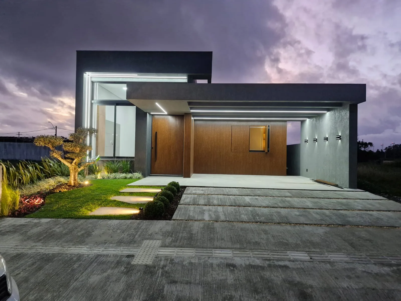 Fachada concluída de residência contemporânea iluminada ao entardecer